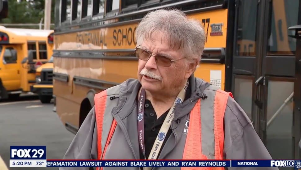 Rich Kutz being interviewed in front of a bus for Centennial School District.