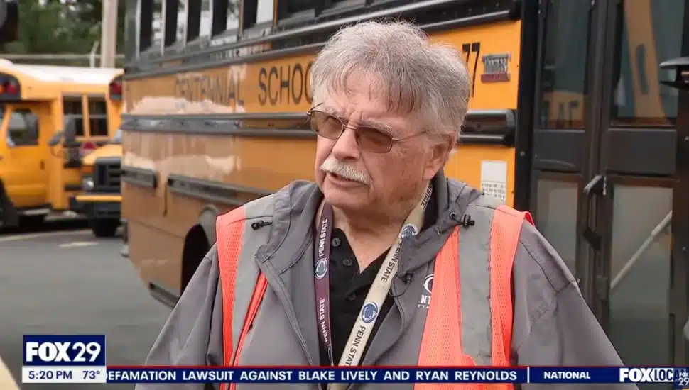 Rich Kutz being interviewed in front of a bus for Centennial School District.
