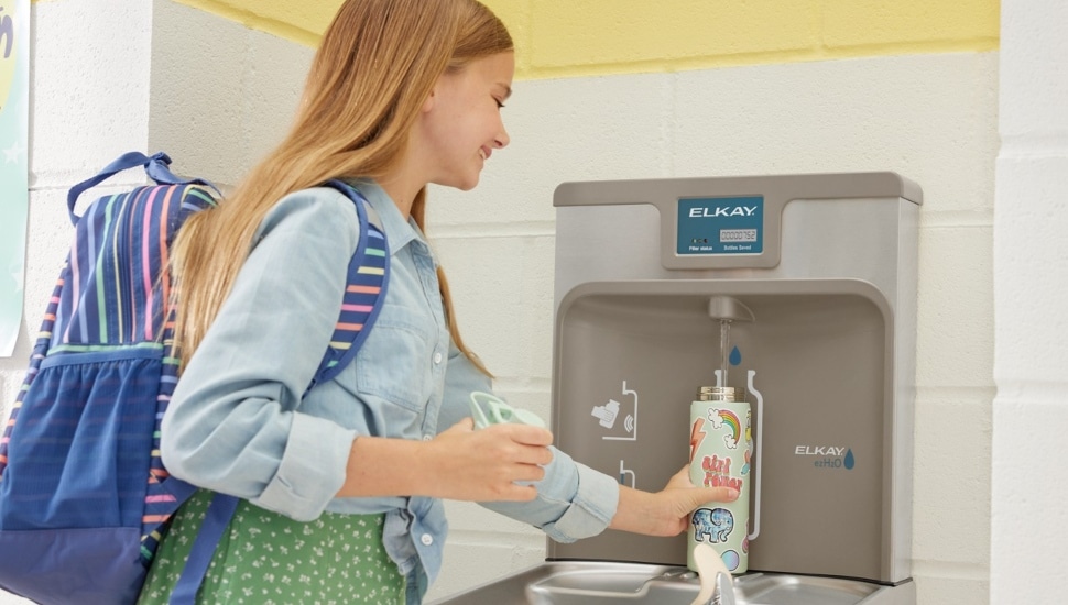 Young girl using an Elkay water bottle filling station.
