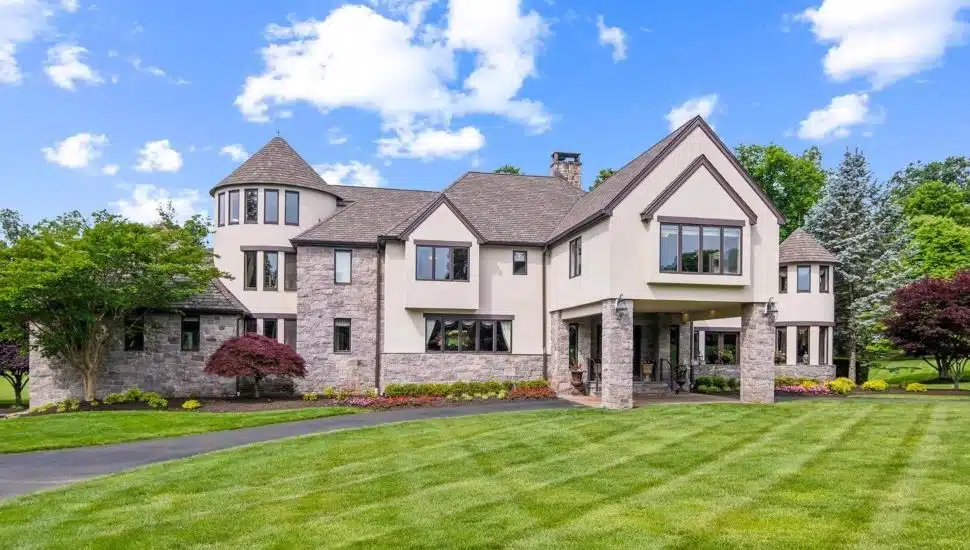 Large colonial mansion with a manicured lawn.
