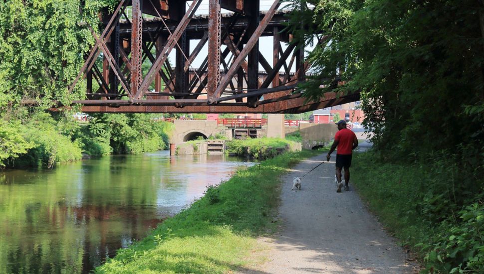 Delaware Canal State Park path under a metal bridge.