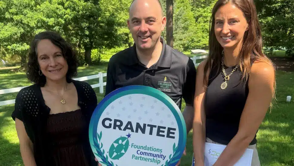 Delaware Valley University rep receives a placard for the Foundations Community Partnership grant.