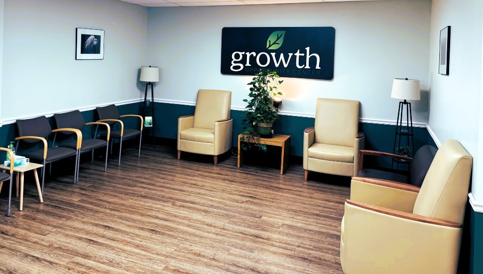 Doctor's office waiting room with wood floor and brown chairs.