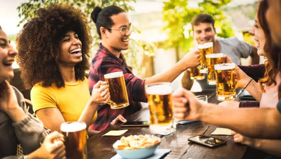 Group of people enjoying beer in beer garden.
