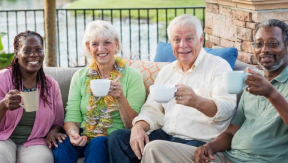 A group of seniors drinking coffee at their senior living community.
