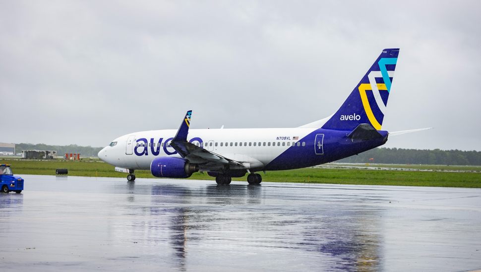Avelo plane on rainy tarmac.