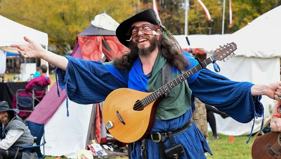 Man dressed in costume holding a lute.