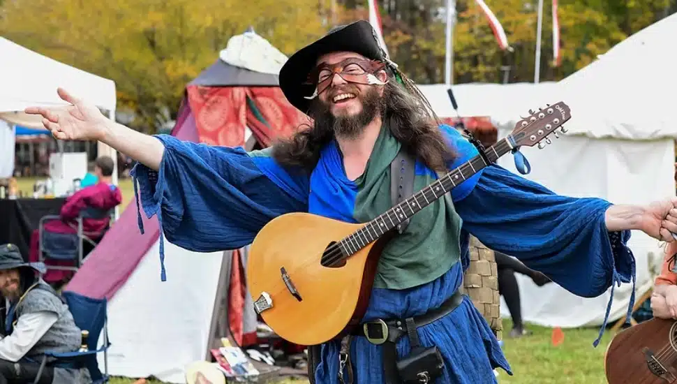 Man dressed in costume holding a lute.