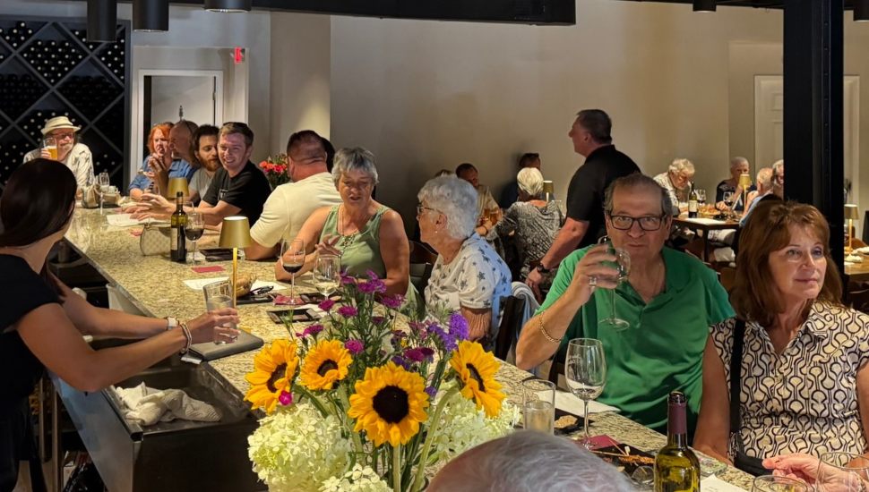 Group of people gathered at John Robert Cellars, talking and drinking.