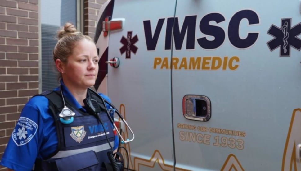 Paramedic Kate Denney in front of an ambulance.