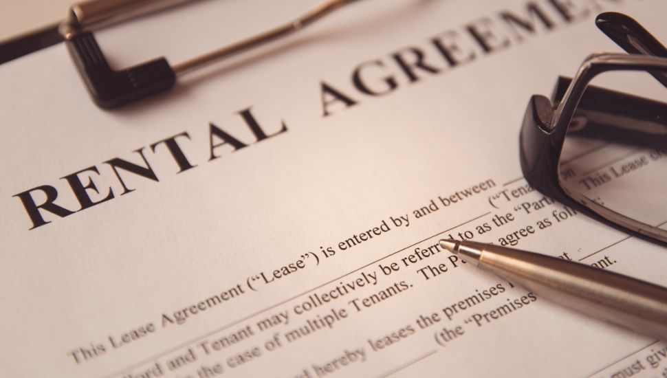 Rental agreement form with a pen and glasses placed on top.