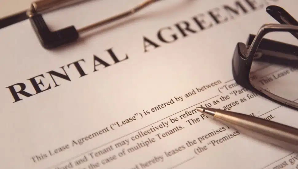 Rental agreement form with a pen and glasses placed on top.