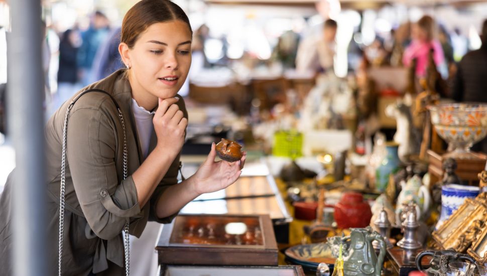 Young woman browsing interesting antique things.