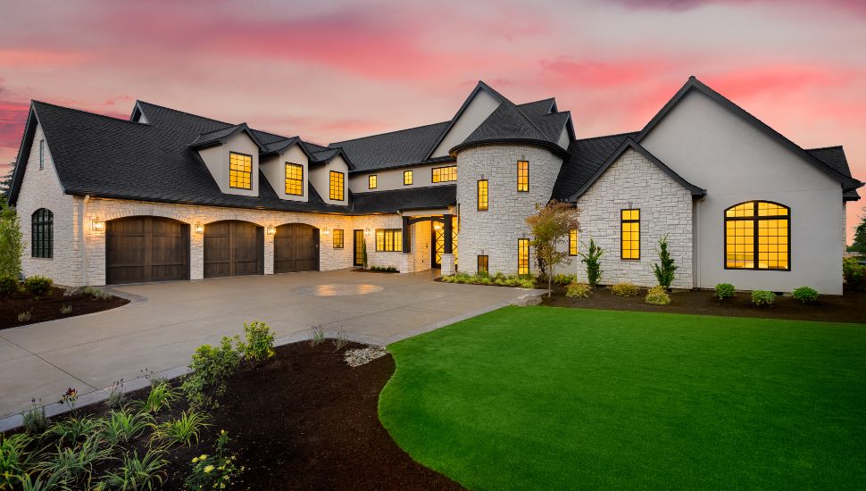 Large white home with manicured lawn.