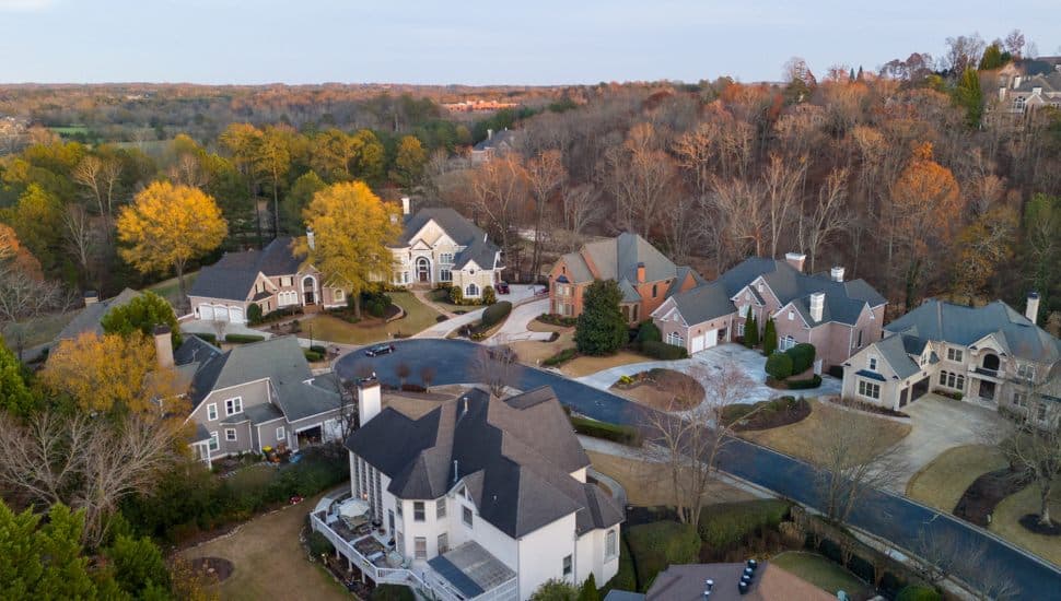 Seven large homes in community surrounded by trees.