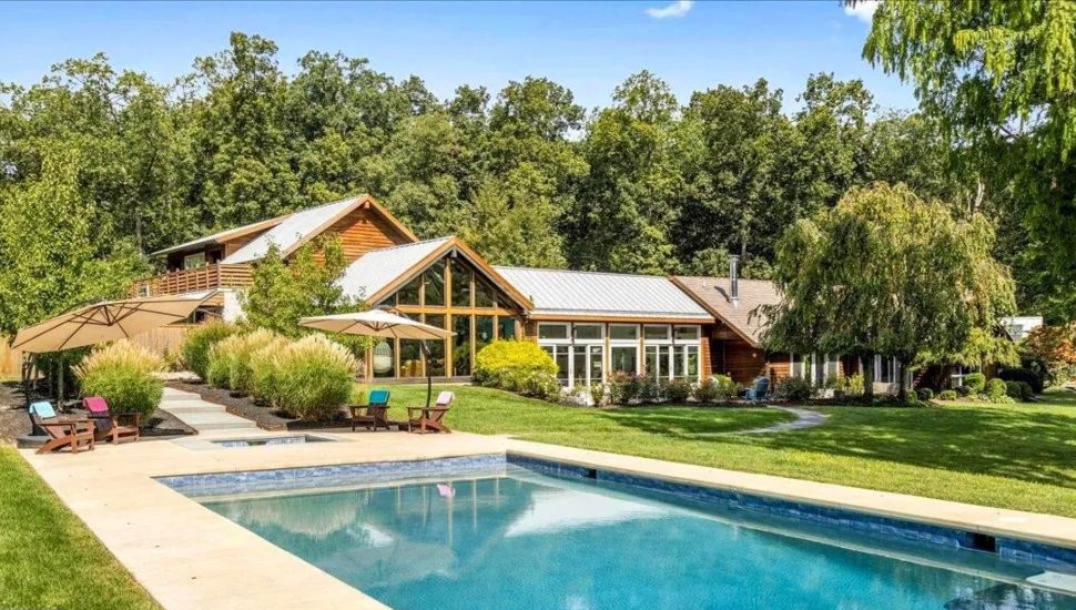 Home featuring natural wood paneling, an abundance of windows and a large in-ground pool.