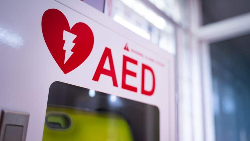 An automated external defibrillator (AED) in a white box.