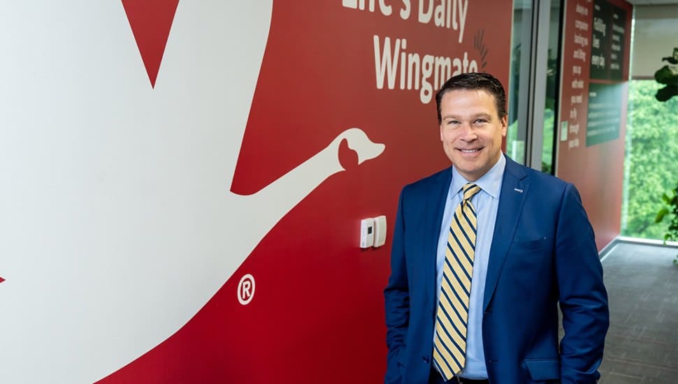Brian Schaller standing beside Wawa logo.