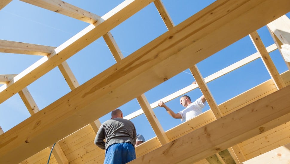 Roof builders mounting prefabricated wooden roof construction.