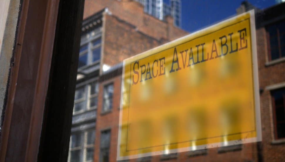 Space available sign in building window.