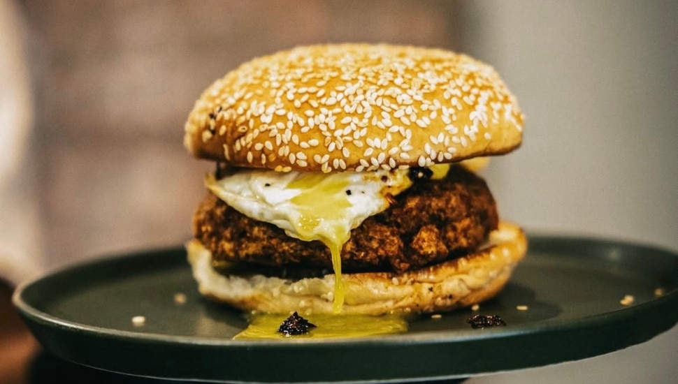 A Korean fried chicken sausage sandwich on a plate.