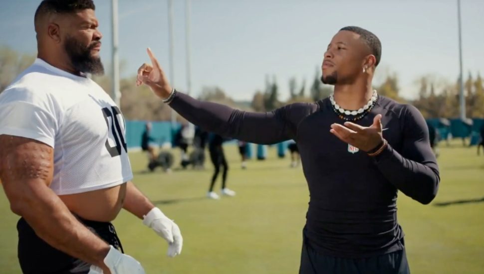 Saquon Barkley on screen with a football actor.