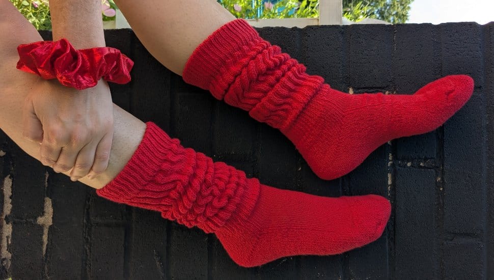 Person modeling red socks and a red scrunchie from Threddies.