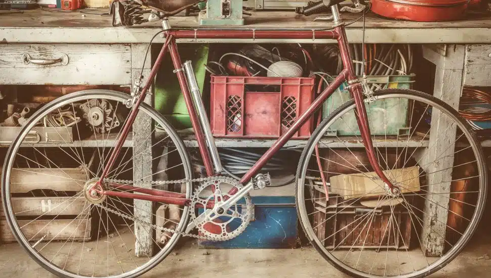 Vintage racing bycicle in front of an old work bench with tools in a garage.