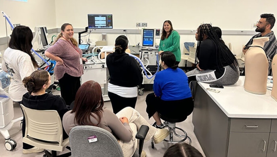 Professor and healthcare students in a simulation lab.
