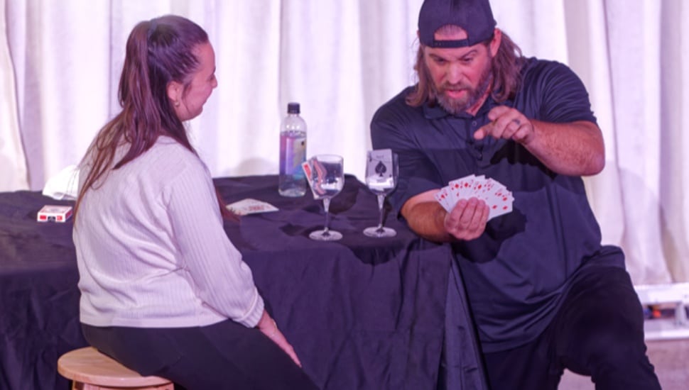 Magician performs magic for corporate audience.