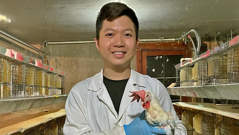 Animal science professor holds a hen.