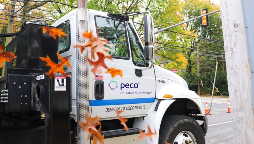 Utility truck seen through fall leaves.