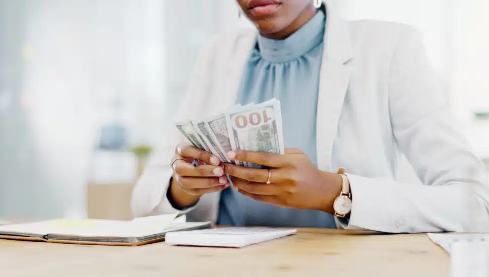 Woman counting hundred-dollar bills.