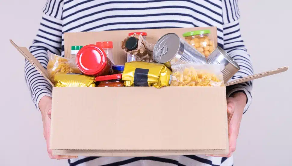 Person holding box of food.