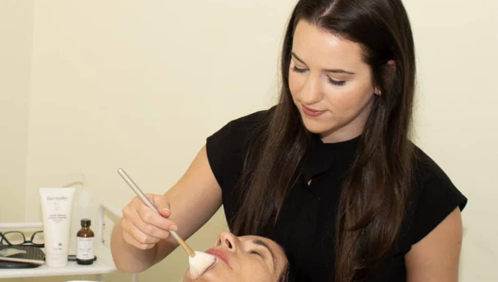 Remy Weil applying facial to client.