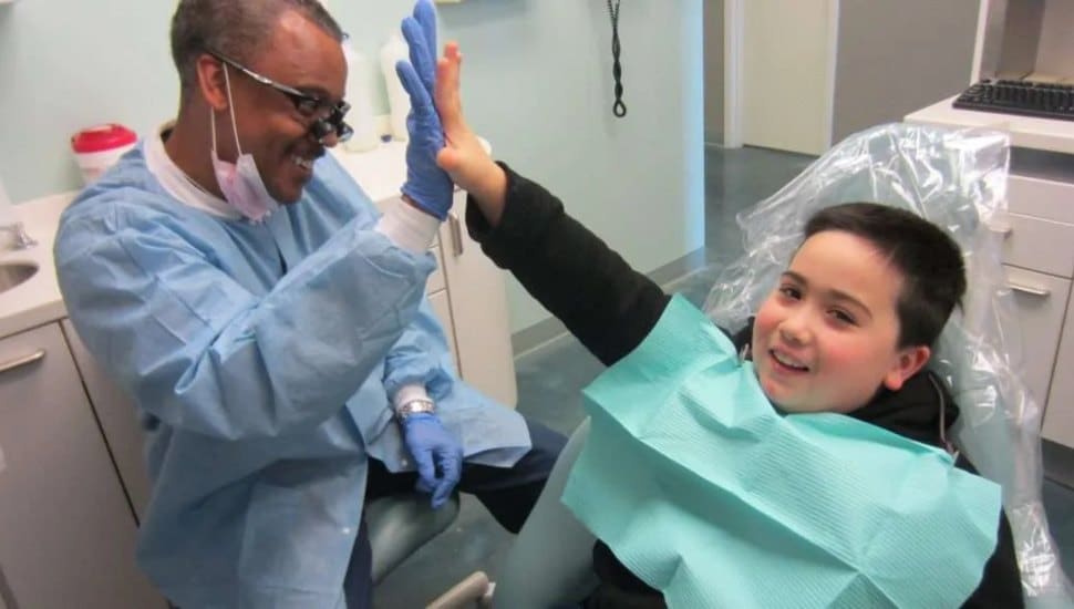 Dental hygienist high-fiving boy.