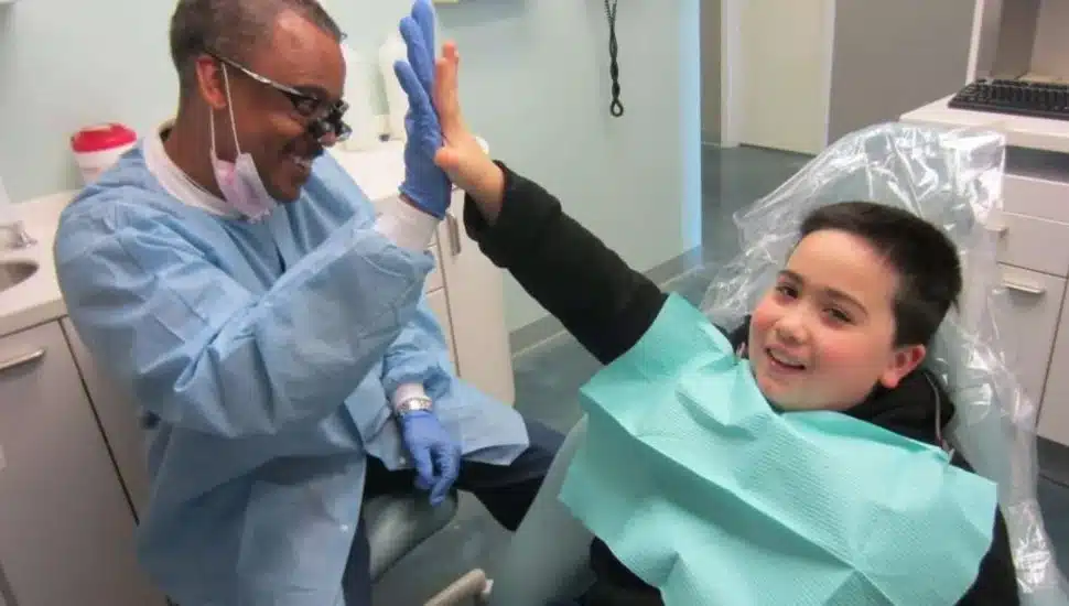 Dental hygienist high-fiving boy.