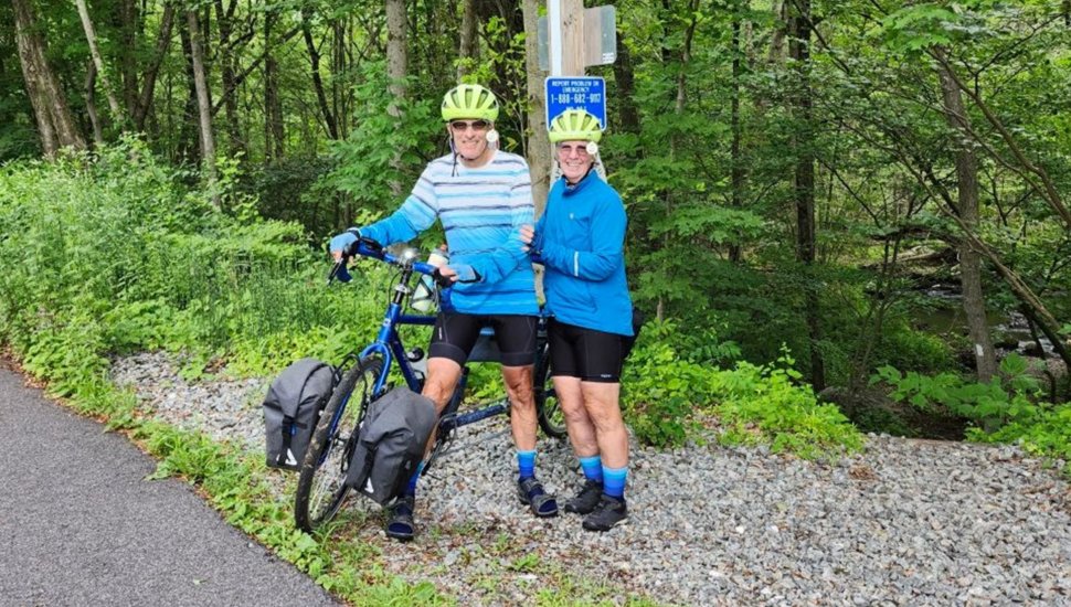 Older couple poses for picture on a bike path.