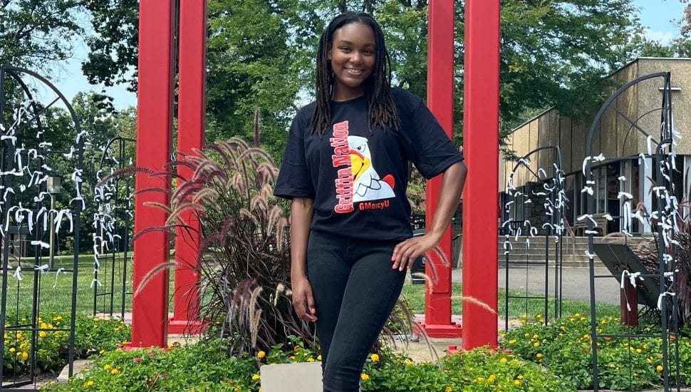 Female college student poses for picture on campus.
