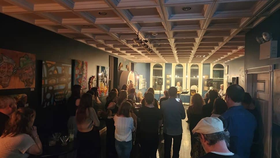 People gathered to watch a performer during a SPEAKeasy event in ArtWRKD.