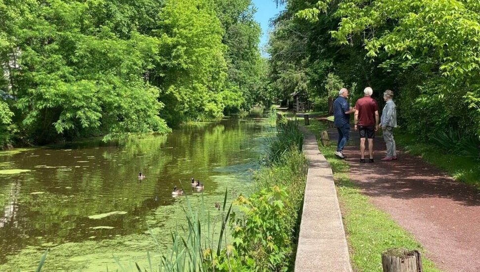 People standing next to the Delaware River Towpath Trail.