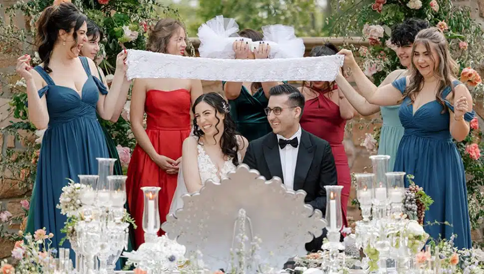 Rachel Galvao and Rameen Vafa sitting at table with bridesmaids.