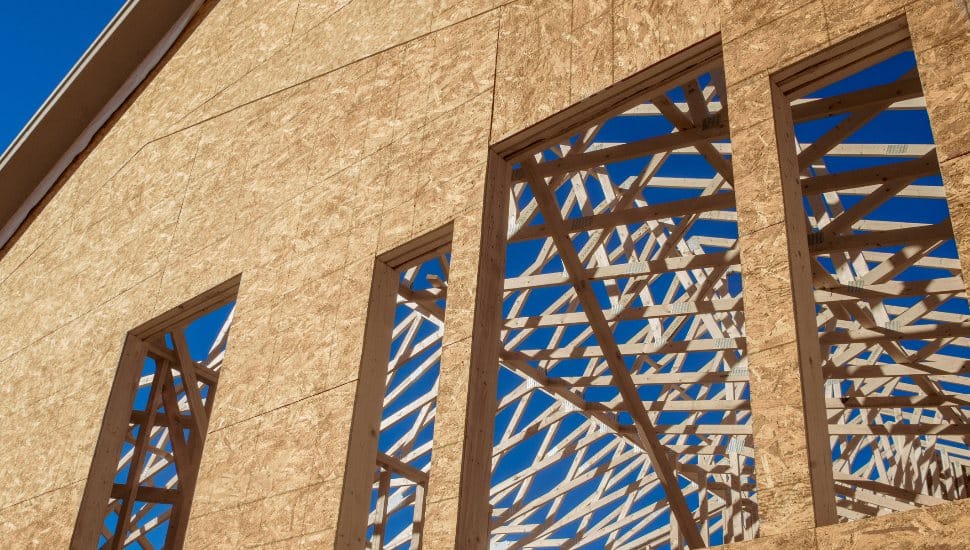 Sheets of oriented strand board on the side of a house under construction.