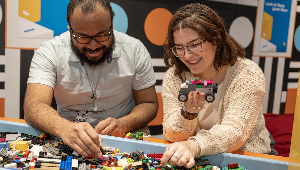 Adults playing with Legos.