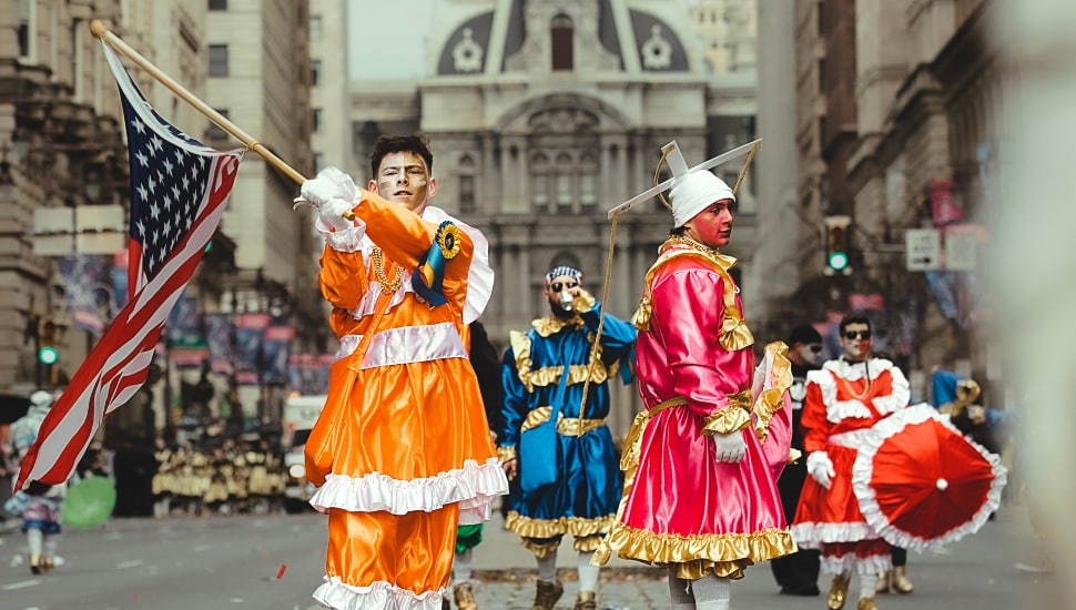 Mummers march past City Hall.