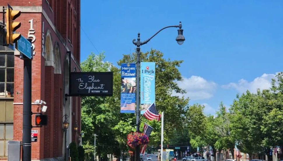 An 'iPickPottstown' sign hangs from a lantern in downtown Pottstown.
