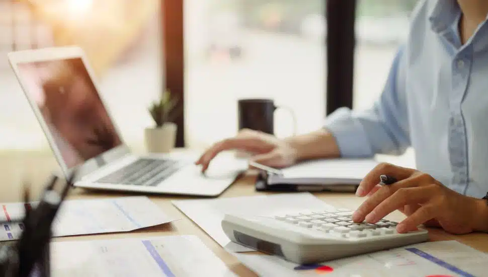 Businessman calculating finances at office desk.