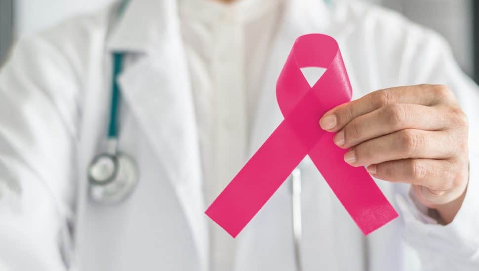 Doctor holding pink cancer ribbon.