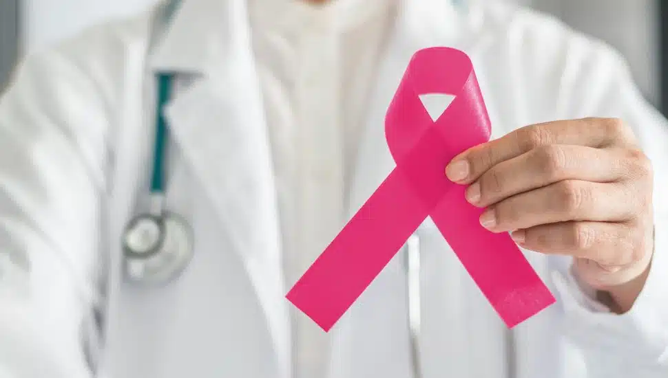 Doctor holding pink cancer ribbon.