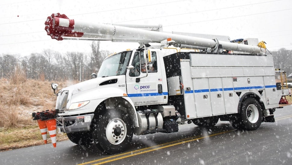 Utility truck driving in snow.